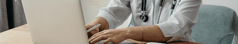 physician typing on computer