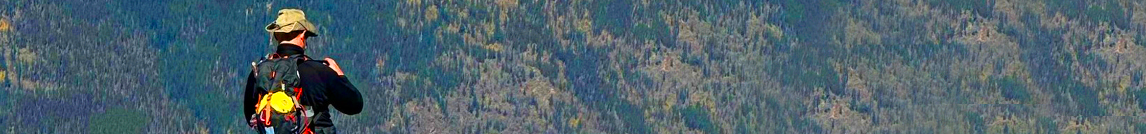 ingenious med's stephen besch standing on a cliff overlooking a mountain range