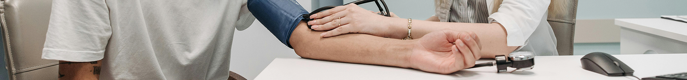 doctor providing patient care by taking blood pressure